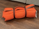 Rolled and strapped, orange ripstop shell
